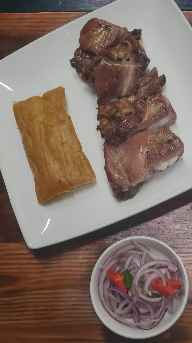 Tamal con chicharrón y salsa criolla