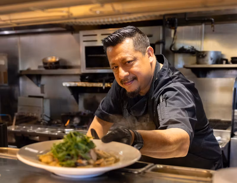 Tutto Fresco chef presenting a finished plate from the kitchen