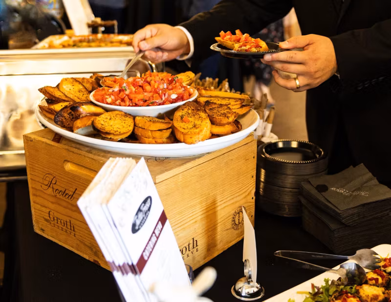 Server presenting bruschetta at a catered event