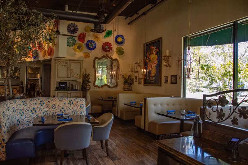 Dining room booths beneath the colorful glass plate wall