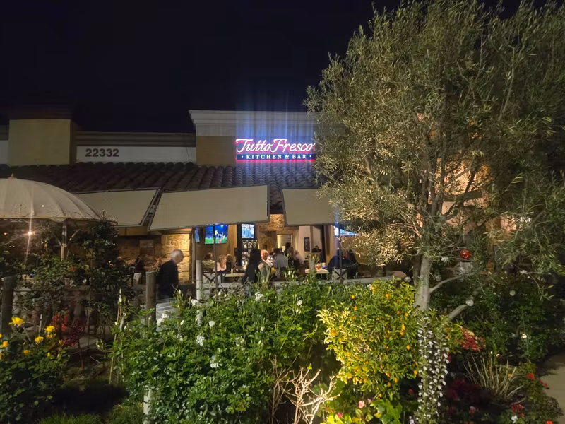 Evening on the patio under the lit Tutto Fresco sign