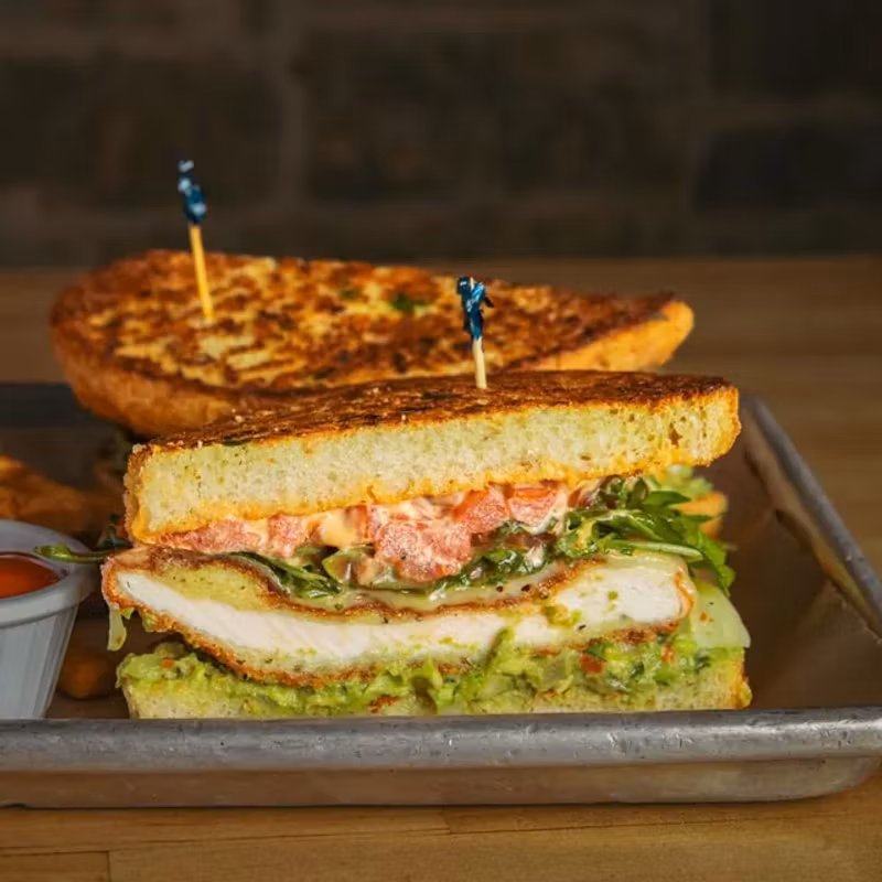 Chicken parmigiana sandwich with avocado smash on toasted sourdough