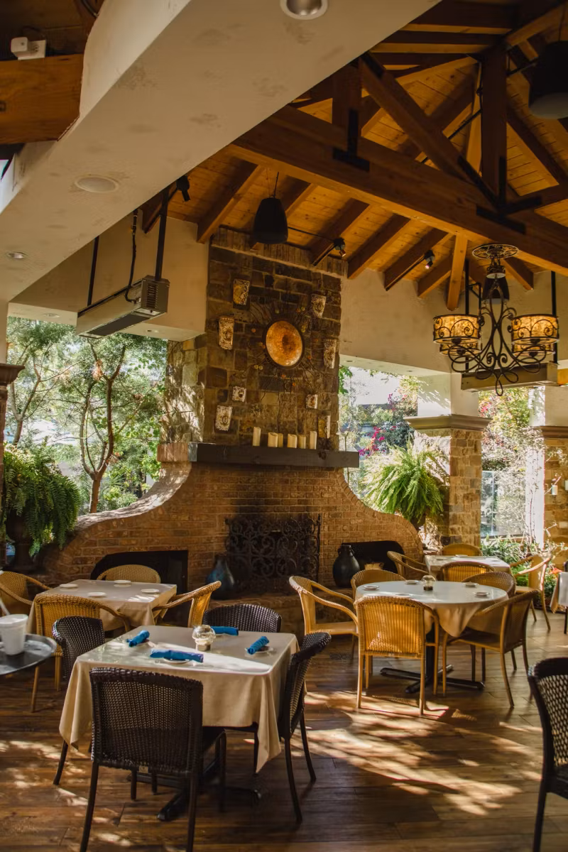 Covered patio with stone fireplace and timber beams
