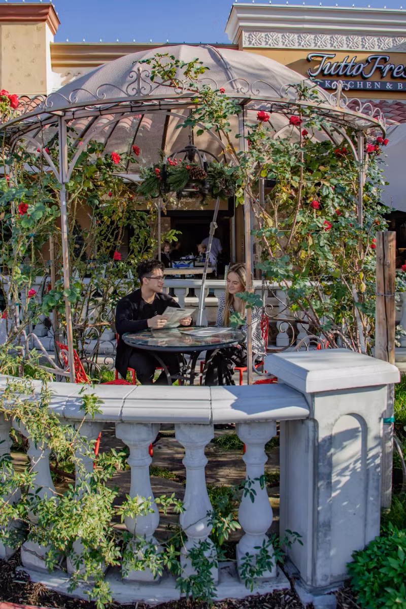 Guests dining in the rose-covered patio gazebo